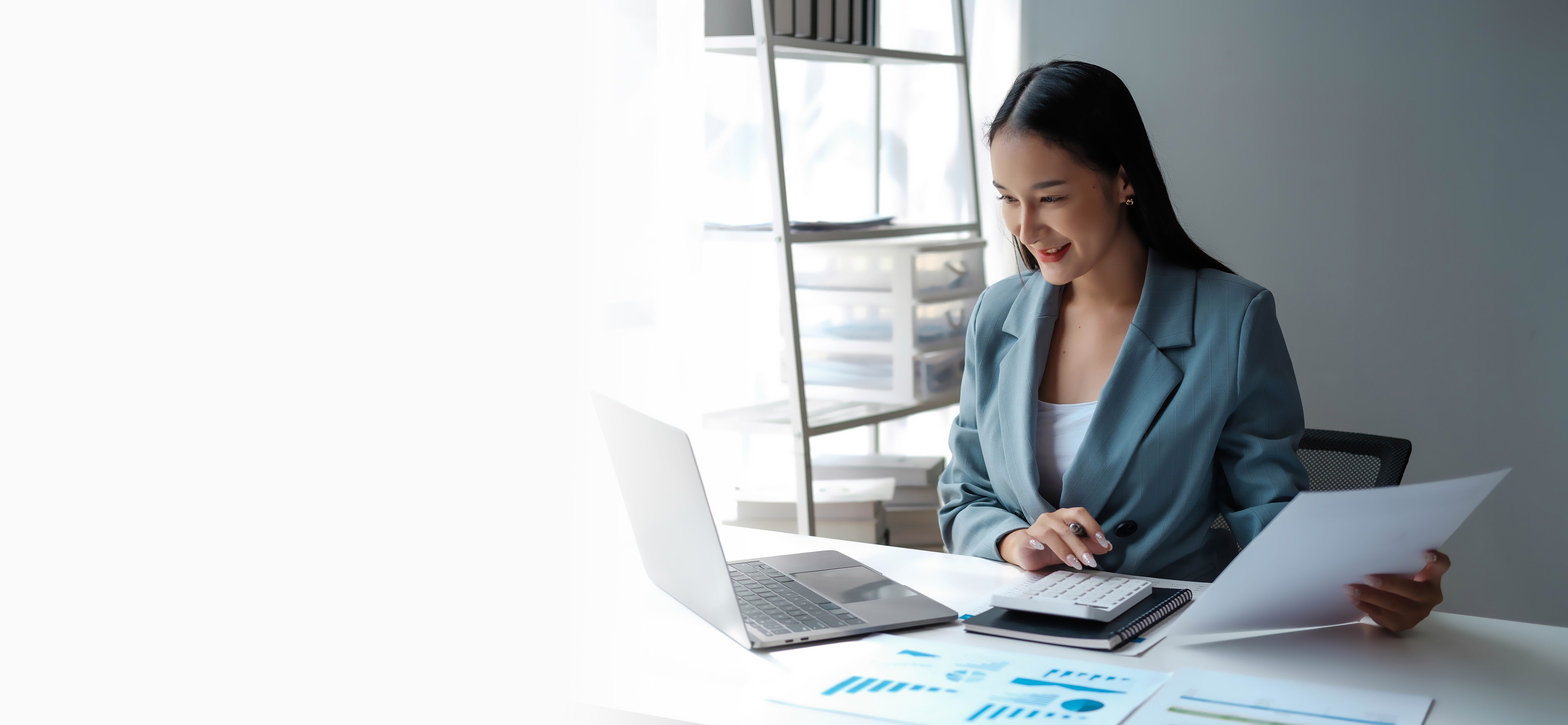 Young happy businesswoman using computer in office, Stylish Beautiful Manager Smiling, Working on Financial and Marketing Projects, Portrait of a young businesswoman working on a laptop in an office